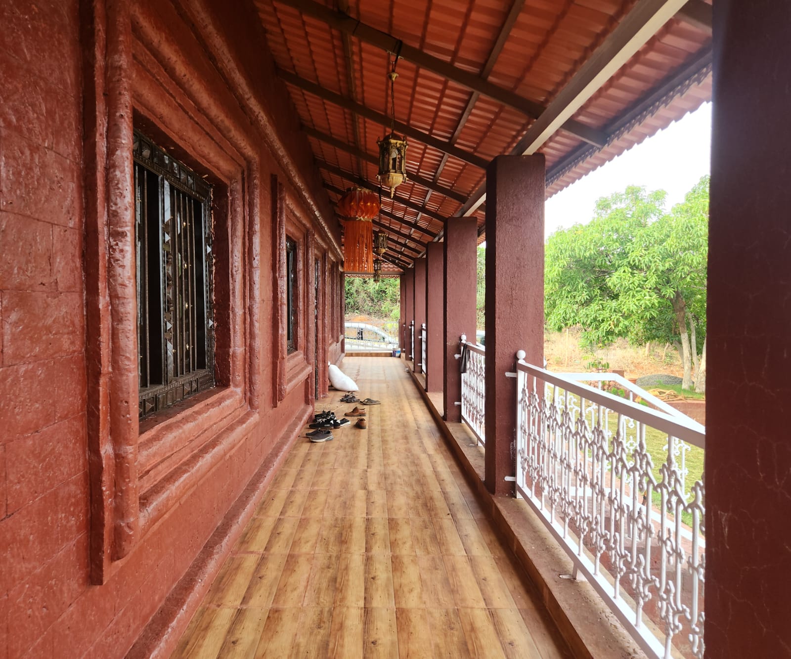 Veranda corridor with hanging lanterns and laterite stone walls